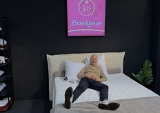 Arjan den Ouden van Lots of Textiles, de Benelux agent voor Brinkhaus, poseerde op een bed met kussens en een dekbed van het Duitse merk.