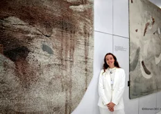 Yentl Van der Plas van McThree Carpets poseert bij vloerkleden van ontwerpster en kunstenaar Angeline Catteeuw, gebaseerd op haar schilderijen. 
