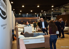 Jean-Pierre Willems, district manager van Simmons - Sleepeezee, geeft druk gebarend tekst en uitleg aan een proefliggende bezoeker.