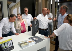Marc van der Staaij (links) van gordijnleverancier en -fabrikant Kendix / De Ploeg in gesprek met zijn collega Froukje met achter haar René, terwijl andere collega's in gesprek zijn met klanten.