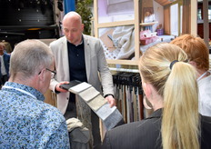 Een medewerker van Vadina toont de nieuwste stoffen.