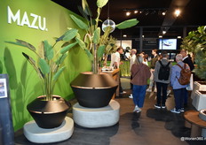 Christophe Scheyvaerts (links) druk in gesprek met bezoekers over zijn MAZU, dat voorop wil lopen in het ontwerpen van duurzame en esthetische oplossingen voor verlichting en decoratie. De aluminium potten van MAZU worden afgewerkt met een eco-vriendelijke poederlak van Sherwin Williams, wat zorgt voor een duurzame en langdurige kwaliteit.