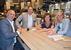 Rob Appel (tweede van links) en Agaath den Heijer (rechts) van Holland Haag in gesprek met de bezoeker Ruud Molenaar (links) en zijn echtgenote Marian.