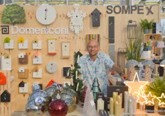 Robin Punt van Sompex in zijn stand op de beurs poserend voor en achter zijn collectie koekoeksklokken en kerstverlichting.
