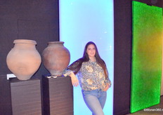 Projectadviseur Estée Lasschuijt van Michel Oprey & Beisterveld poseert bij twee nieuwigheden, waaronder een van Heineken bierflessen gemaakt product dat onder meer als tafelblad is te gebruiken.