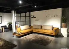 De okergele zitbank van het merk ZIZEAU van Meubitrend was een ware blikvanger in de showroom.