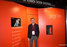 Laurens Vermeulen in de stand van Xinnix Door Systems. Al het deurbeslag zit verborgen en er is geen omlijsting rond de deur zichtbaar. Dit resulteert in een enorm strakke afwerking waar de deur volledig vlakwandig is.
